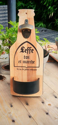 Décapsuleur mural artisanal en bois naturel, avec gravure humoristique et réceptacle à capsules amovible. Un accessoire pratique et original pour votre coin apéro. 🍻