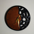Horloge murale artisanale de 24 cm, associant bois naturel et impression 3D noire au design géométrique ajouré. Une création moderne et originale qui apporte une touche unique à votre décoration. 🕐