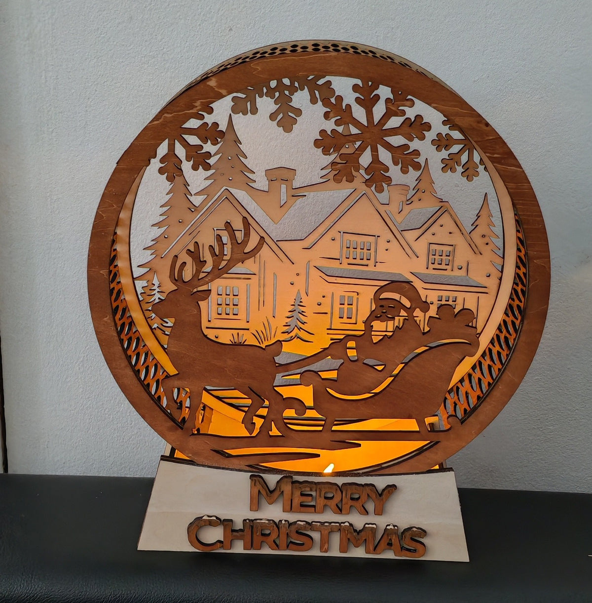 🎅✨ La magie de Noël s'illumine !
Une décoration en bois multicouche représentant le Père Noël et son traîneau devant un village enneigé, sublimée par une douce lumière chaleureuse.