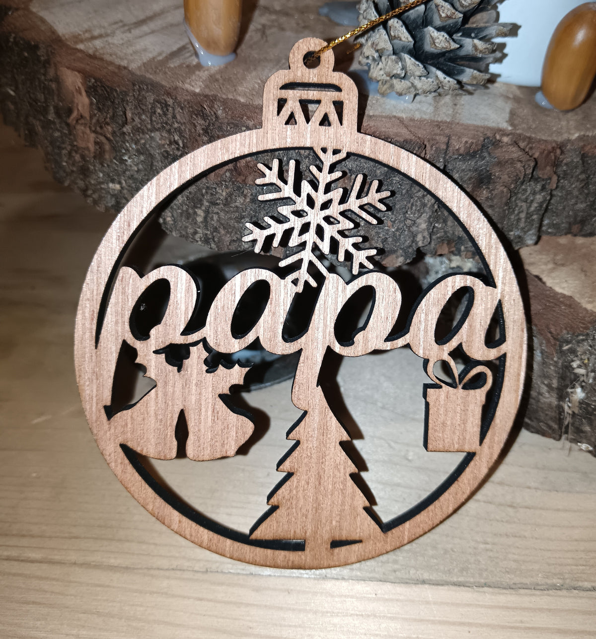 Boule de Noël personnalisée en bois gravée Papa, suspendue dans un sapin.