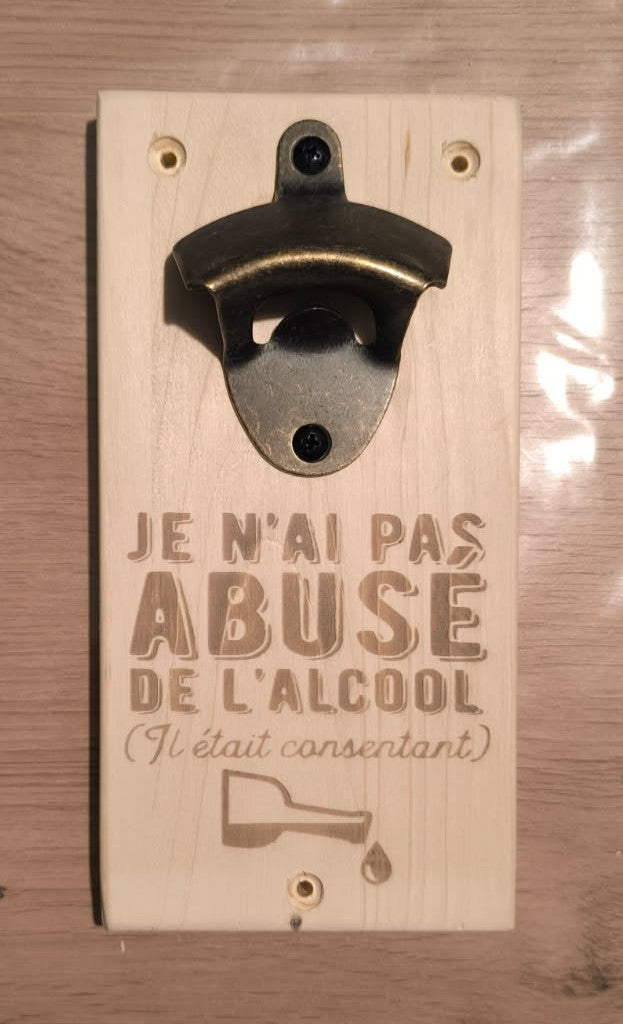 Décapsuleur mural sur plaque en bois, avec message humoristique gravé et dessin d’une bouteille inclinée