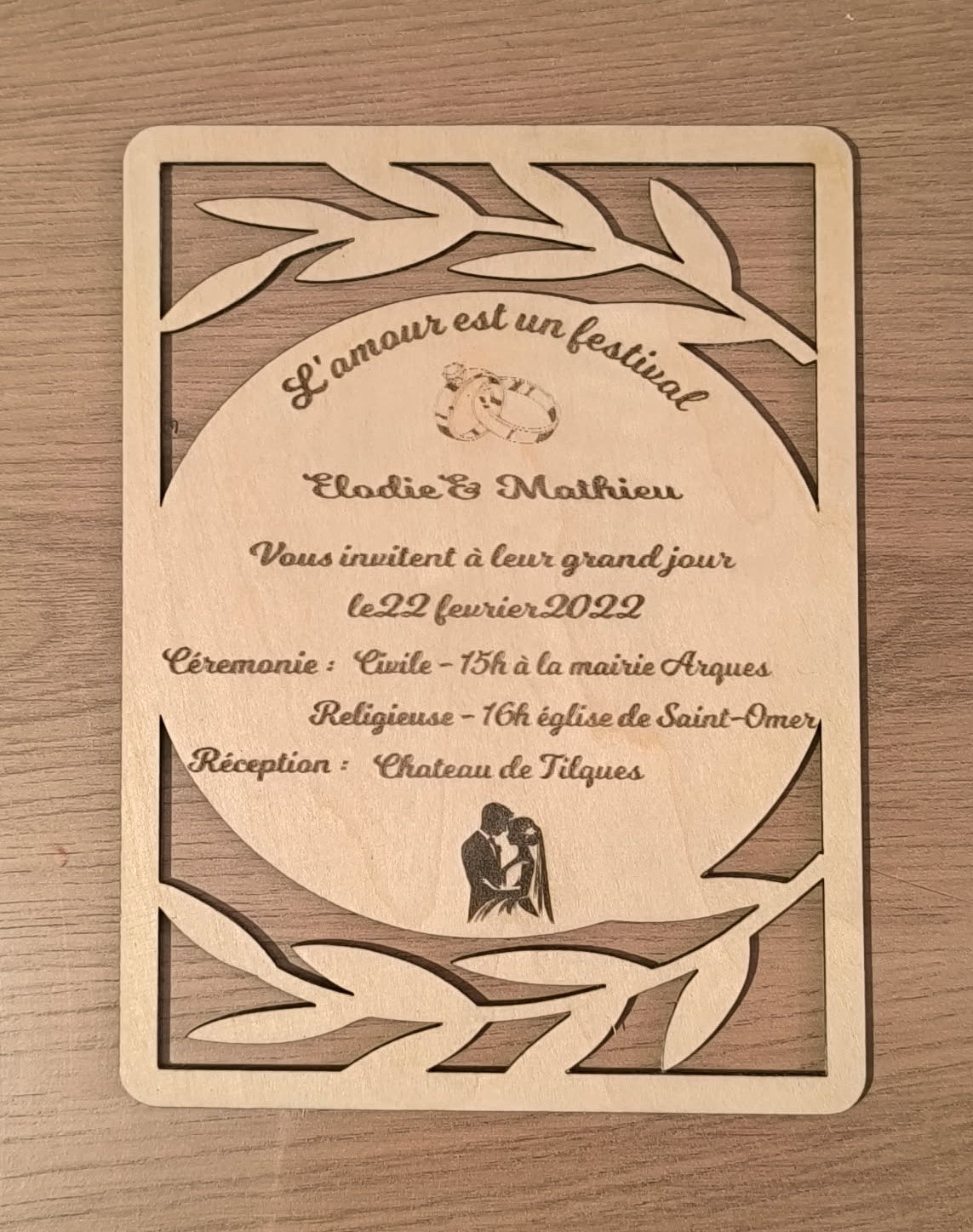 Faire-part de mariage en bois avec texte personnalisé au centre et bordure ajourée de feuillage