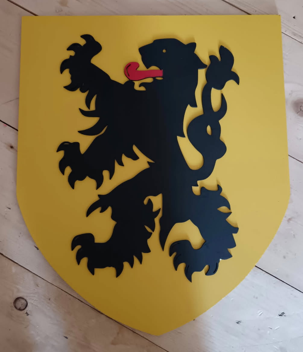 Blason en bois jaune portant un Lion des Flandres noir à langue rouge, posé sur un sol en bois