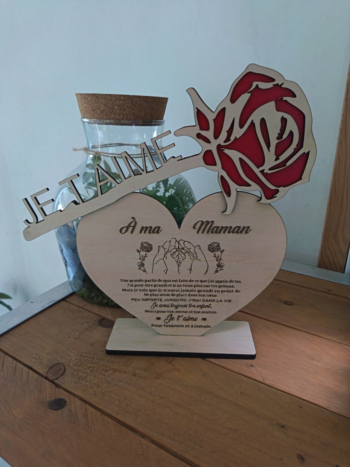 Rose rouge en bois avec inscription Je t’aime et cœur gravé À ma Maman, présentés sur un socle