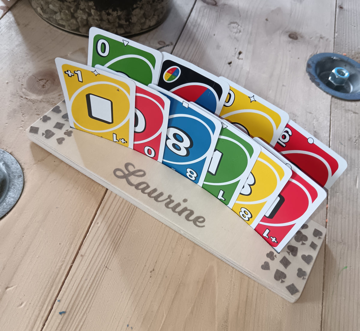 Vue de côté du support de cartes à jouer en bois gravé Laurine, avec deux rangées de cartes colorées